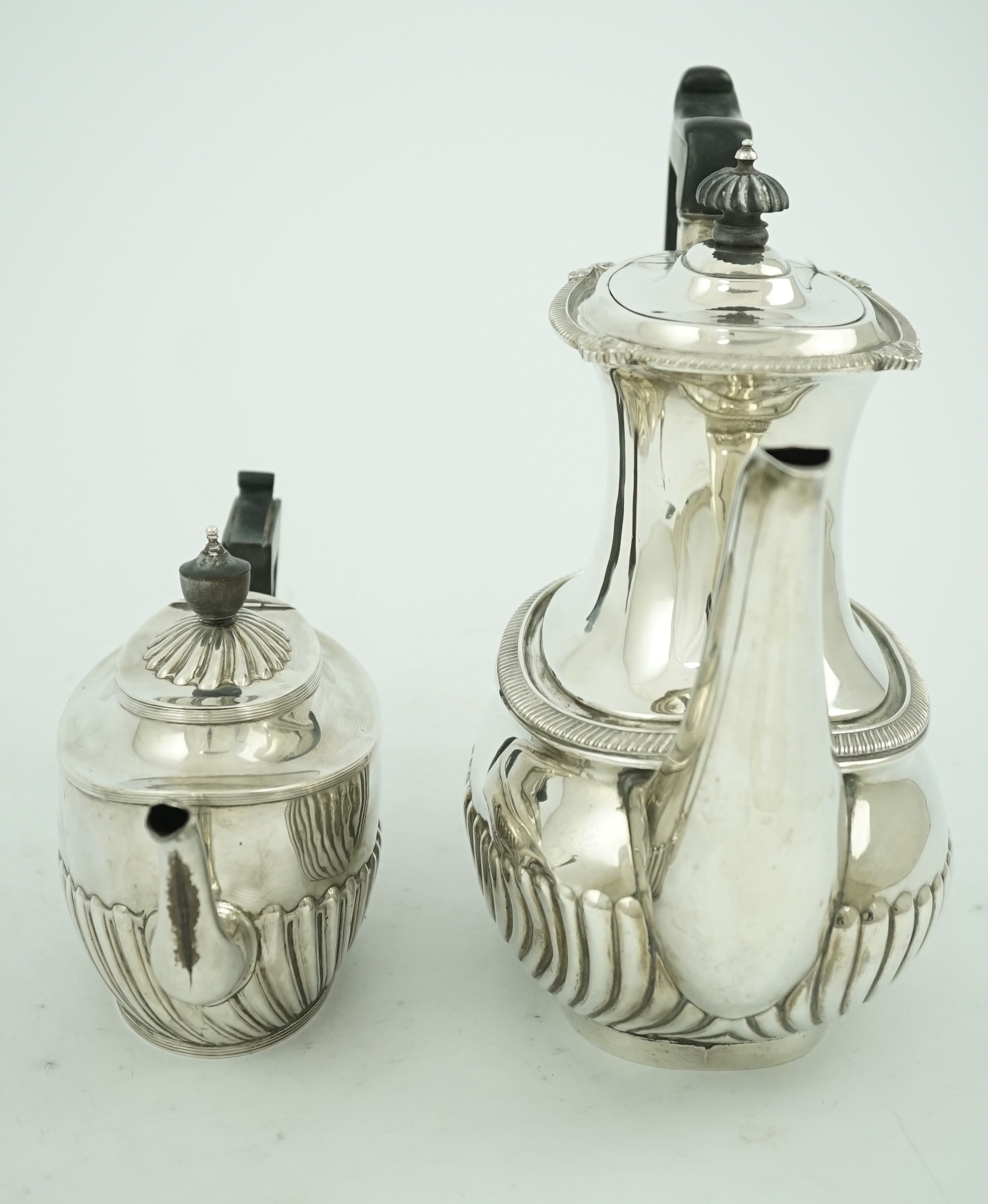 An Edwardian demi-fluted silver oval coffee pot by Mappin & Webb, Sheffield, 1902 and a similar tea pot by Henry Harrison, Sheffield, 1884